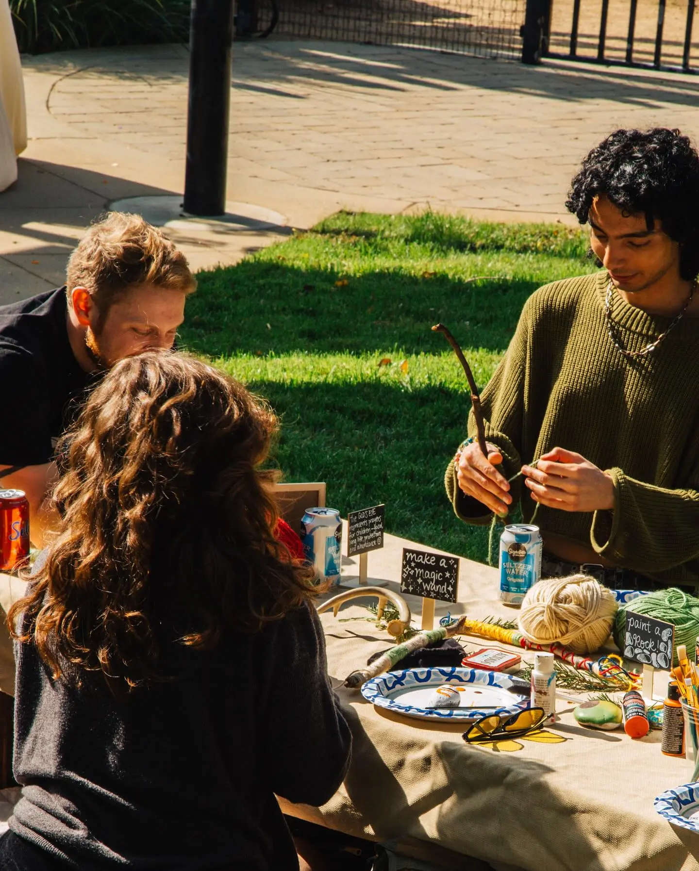People gathered around an outdoor craft table
