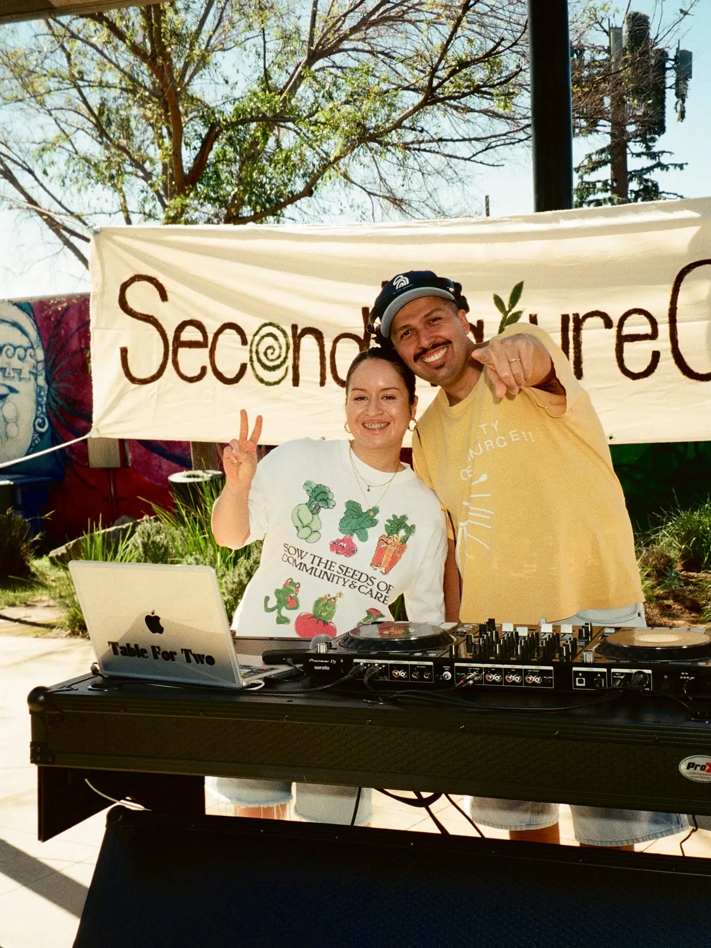 Two DJs smiling behind their equipment