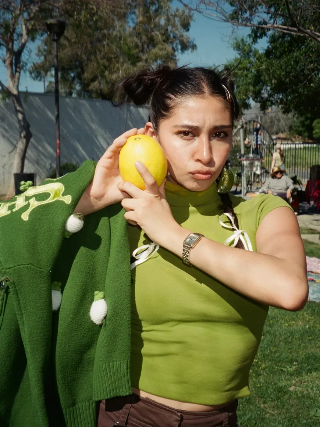 A community member standing near greenery at an outdoor gathering