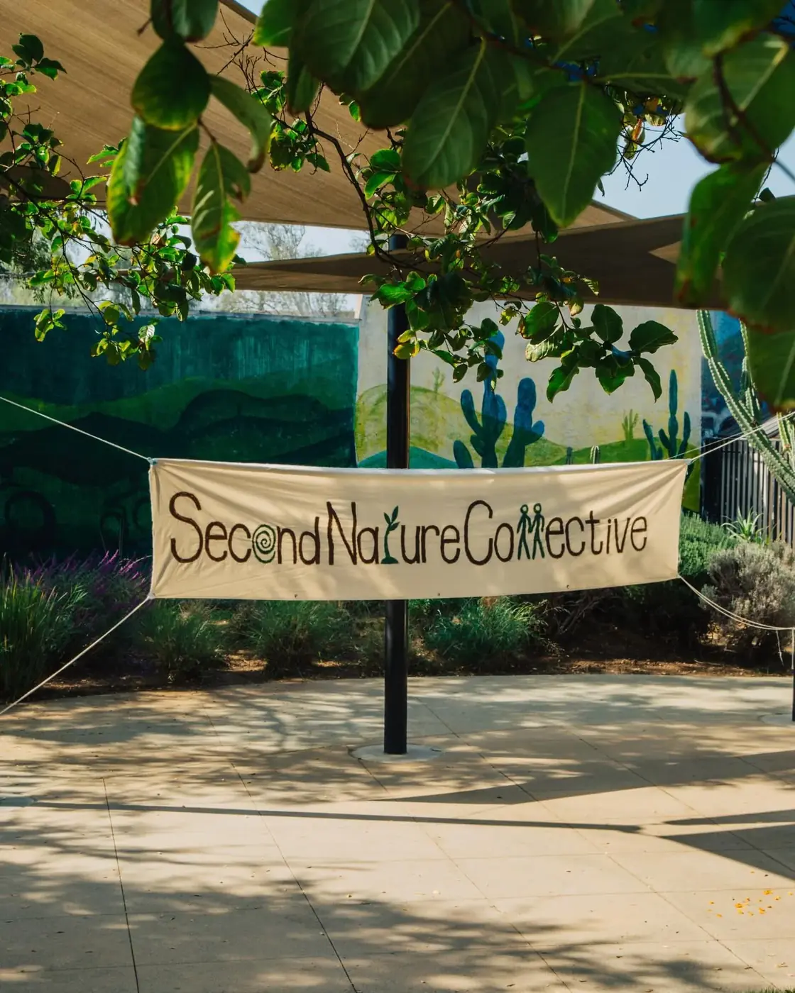 Second Nature Collective banner at an outdoor community gathering